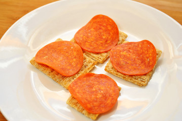 Obraz na płótnie Canvas Pepperoni Slices On Whole Wheat Crackers