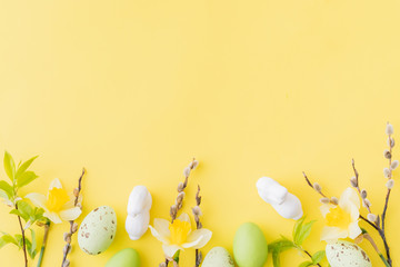 Flat lay easter composition with yellow daffodils and eggs on a yellow background