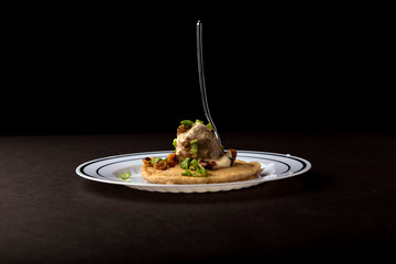 Appetizers on plates with black background