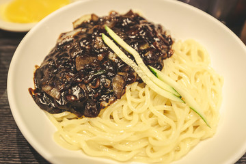 Close up of Jajangmyeon (jjajangmyeon), Chinese Korean traditional noodle dish with diced pork in black soy sauce