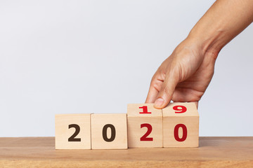 Hand flip wooden cube with the word 2019 to 2020 on white background. Concept for success in the future goal and passing time. Happy new year