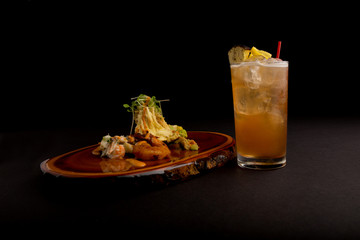 Cocktail and appetizer on black background