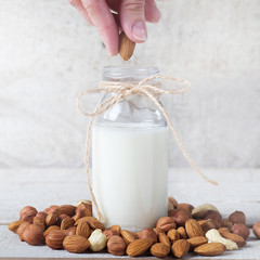 almond milk in white background and almond grains