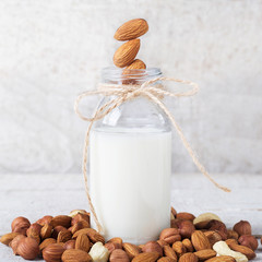 almond milk in white background and almond grains
