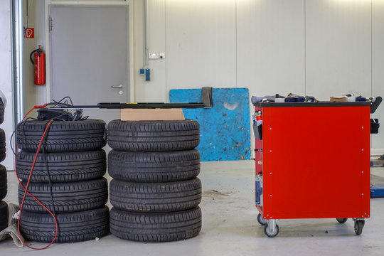 two stacks of car tires and a tool trolley