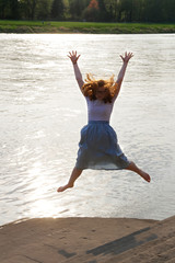 Obraz premium Jugendliche am Fluss springt in die Höhe