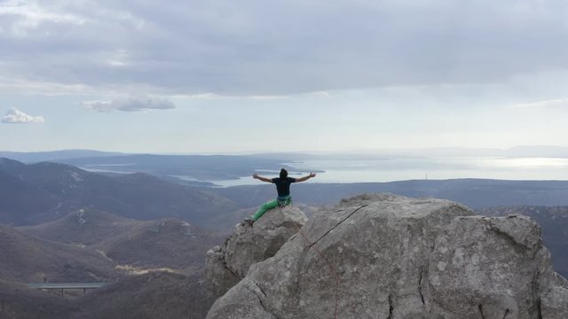 Aerial shot of Young adult guy climbing on a white rock