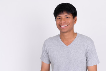 Portrait of happy young Asian man thinking and looking up