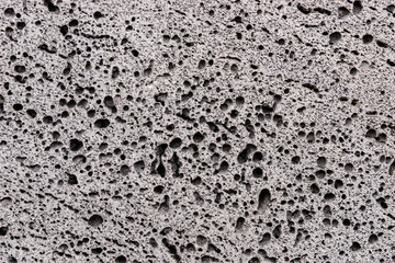 Closeup of gray porous stone textured wall. Stone background - obrazy, fototapety, plakaty