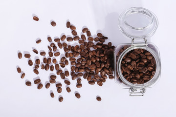 A jar of fresh fragrant coffee beans, on a white background. Hard shadow from the sun, art concept of morning and energy charge