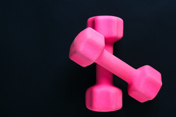 pink dumbbbells on black background