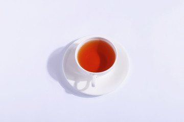 Ceramic cup with tea, on a white background. The harsh shade of the sun, the art concept of the morning and the charge of energy.