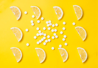 Vitamin C. Slices of lemon on a bright background and vitamin C pills. Beauty product branding mock-up. Top view.