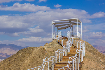 white observation deck high point view in Israel bare mountain top peak on blue sky background...