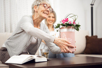 Middle-aged blonde wants to show the flower box that she got from her husband.