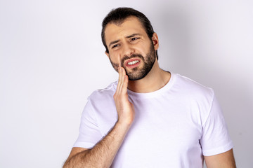 Handsome man in a white T-shirt on a white background, toothache