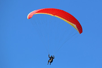 Paraglider flying red wing
