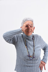 senior woman looking through fingers as if wearing glasses on white background