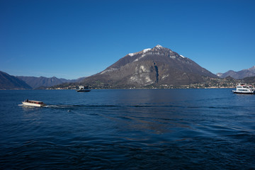 Italy, Menaggio, Lake Como, a large body of water with a mountain in the background