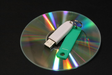 CD with color beams and electronic key on a dark background. Correction fluid,electronic key, DVD...