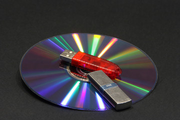 CD with color beams and electronic key on a dark background. Correction fluid,electronic key, DVD...