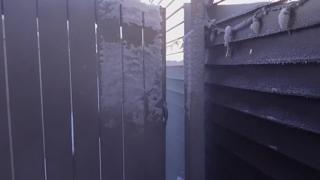 Ice crystals forming on backyard entrance and house wall slomo