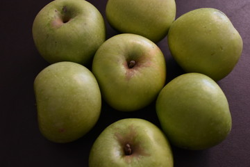Green apples on black background.