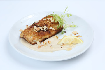 fried tuna with sesame, nuts and white sauce, garnished with young green arugula