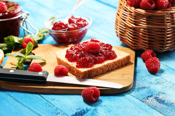 Toast bread with homemade raspberry jam or marmalade on table served with butter for breakfast or brunch