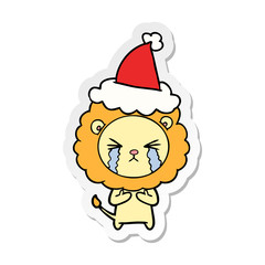 sticker cartoon of a crying lion wearing santa hat