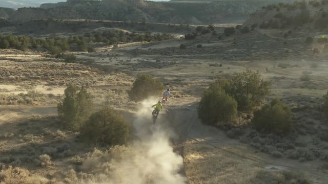 dirt bike riders run through dusty trail in colorado