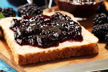 Toast bread with homemade blackberry jam or marmalade on table served with butter for breakfast or brunch