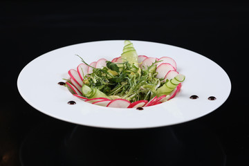 restaurant dish, green salad with radishes, arugula and cucumbers, healthy food, for the menu