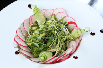 restaurant dish, green salad with radishes, arugula and cucumbers, healthy food, for the menu