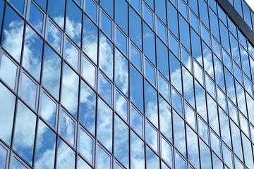 Plakat Surface of glass building with the reflection of clouds