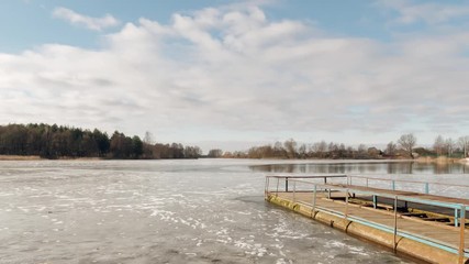 the beginning of spring. jetty on the lake in the ice.
