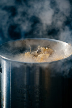 Peanut oil boiling in fryer outdoors with smoke