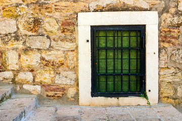 Fototapeta na wymiar Authentic, stone wall, with beautiful, old, wooden shutters and window, minimal style, bright colors, background.
