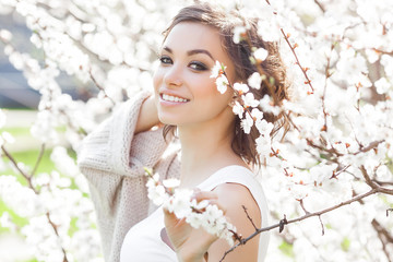 Woman beauty portrait. Young girl outdoor at spring background. Female with flowers. Beautiful lady closeup portrait.