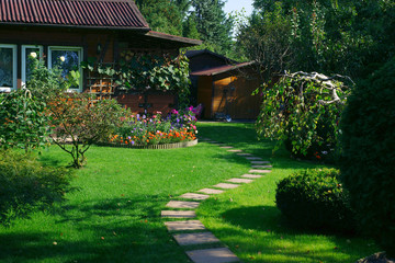 Beautiful lawn and path in a flowering garden - obrazy, fototapety, plakaty