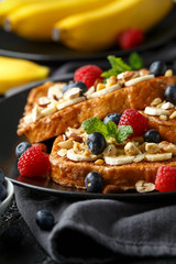 French cinnamon toast with blueberries, raspberries, banana, nuts, hazelnut and honey.