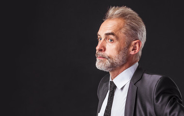portrait of confident businessman in a business suit on a black background
