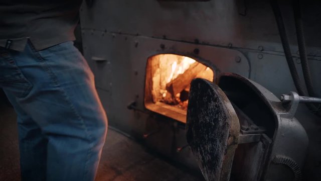 Coffee Roasting Process - Probat coffee roasting machine furnace being filled with wood.