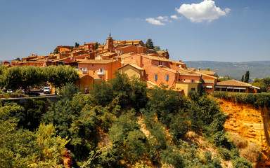 Panoramic view of hilltop medieval ochre village of Roussillon one of the most beautiful villages of France in a sunny summer day. Provence, travel France. - obrazy, fototapety, plakaty