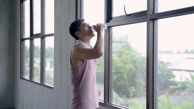 sport asian man drinking water after exercising