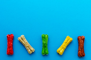 colored chewing bones on blue background