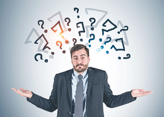 Businessman shrugging shoulders, question marks
