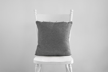 Mockup of a grey square cushion sitting on an old white dining chair.