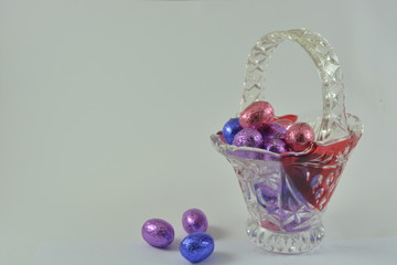 chocolate easter eggs in a glass basket on a white background