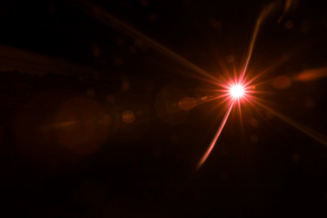 abstract lens flare red light over black background